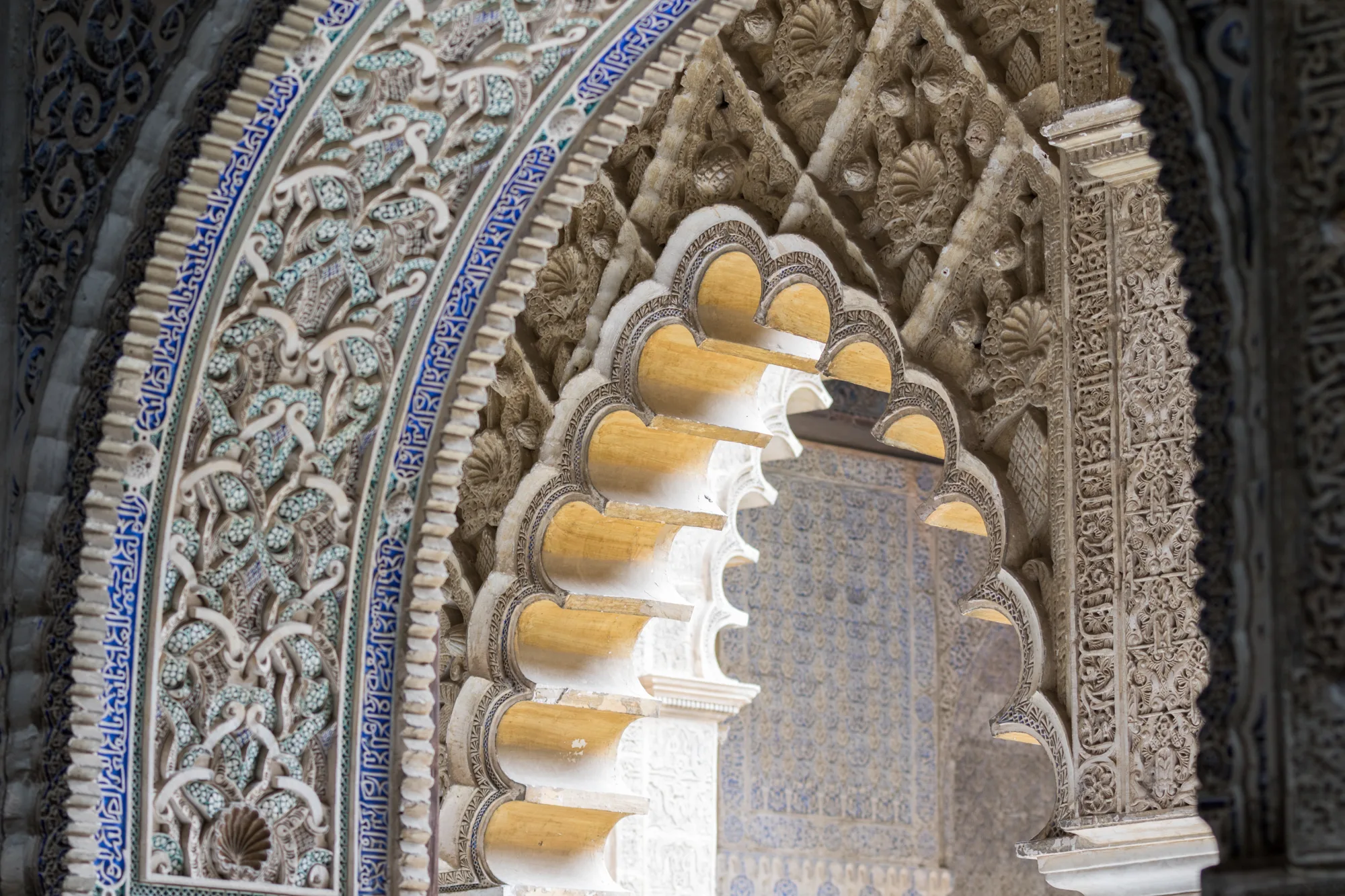 Raskošno ukrašen mudéjar luk sa kaneliranim lukovima, štuko ornamentima i plavo-belim keramičkim pločicama